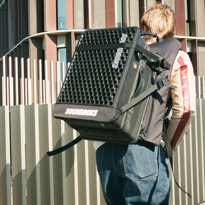 Soundboks Go strapped in Soundboks Backpack carried by a person walking 