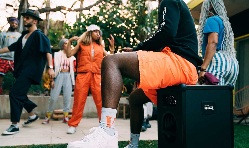 A person sitting on top of a SOUNDBOKS (Gen. 3) at a outdoor party